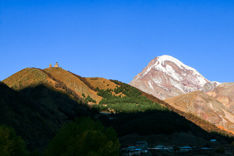 Lever de soleil sur Kazbegi, l'église de la trinité et le Mont Kazbek