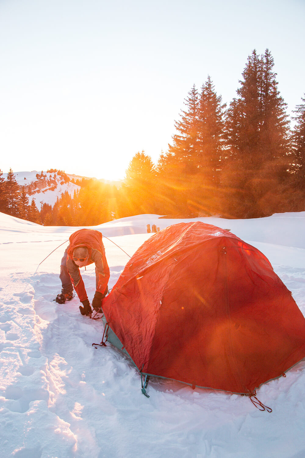 installation des tentes pour le bivouac dans la neige au coucher du soleil